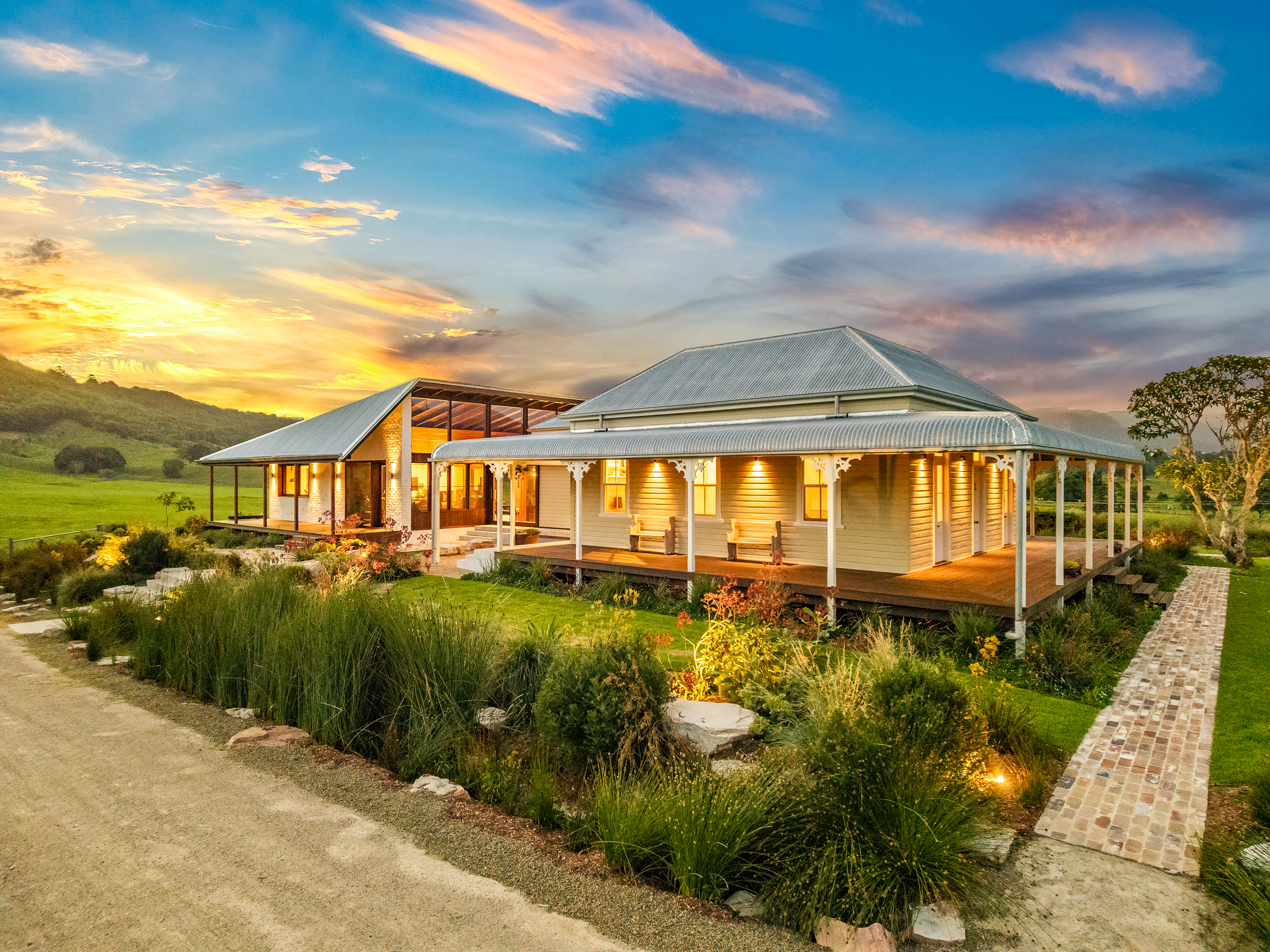 Longfield homestead at twilight with wraparound verandah and sunset sky, Wilsons Creek