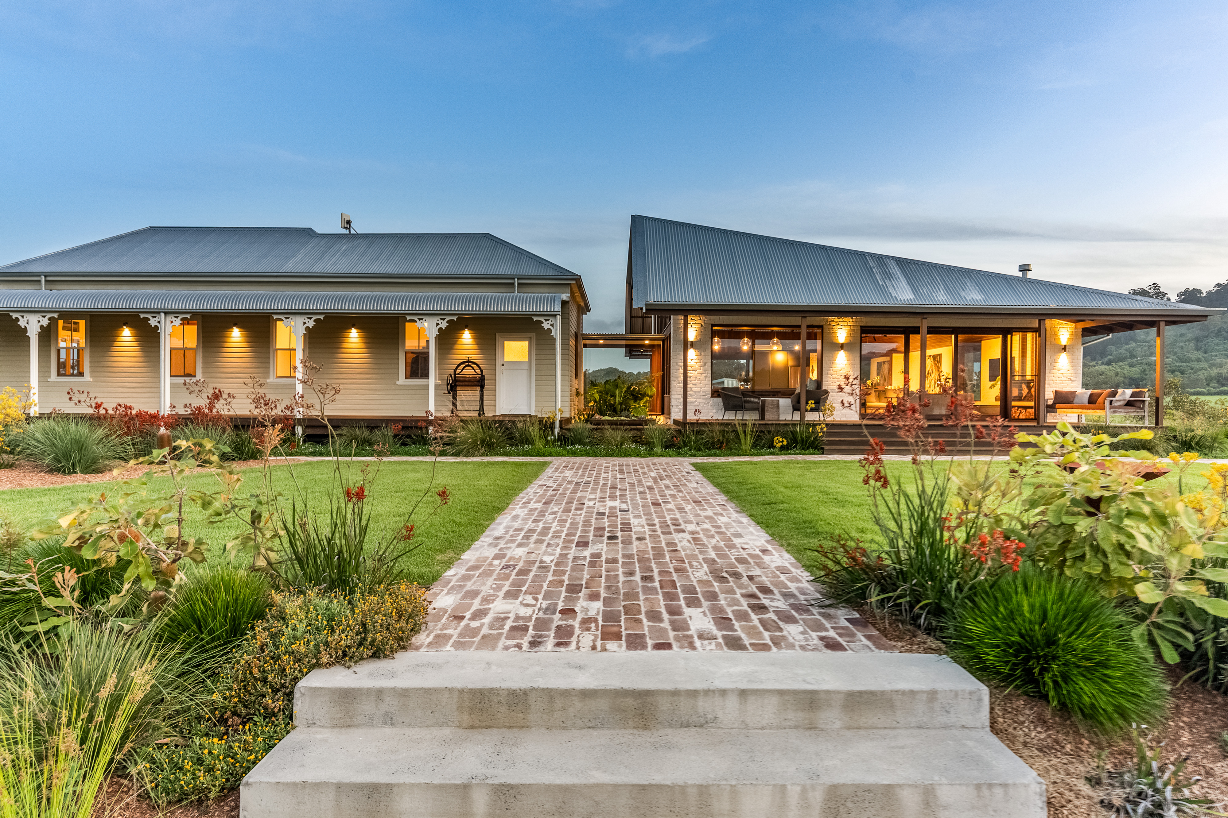 Front approach at dusk showing heritage and modern wings together