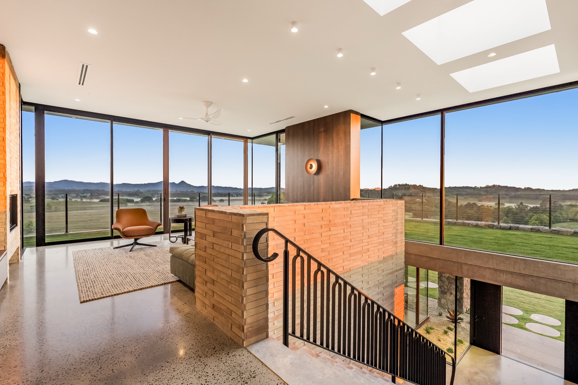 Upper level living with brick balustrade, wrought iron staircase and panoramic views
