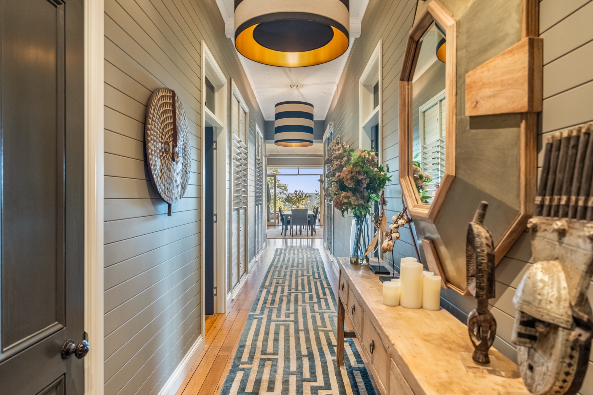 Character hallway with shiplap walls, striped pendants and geometric runner