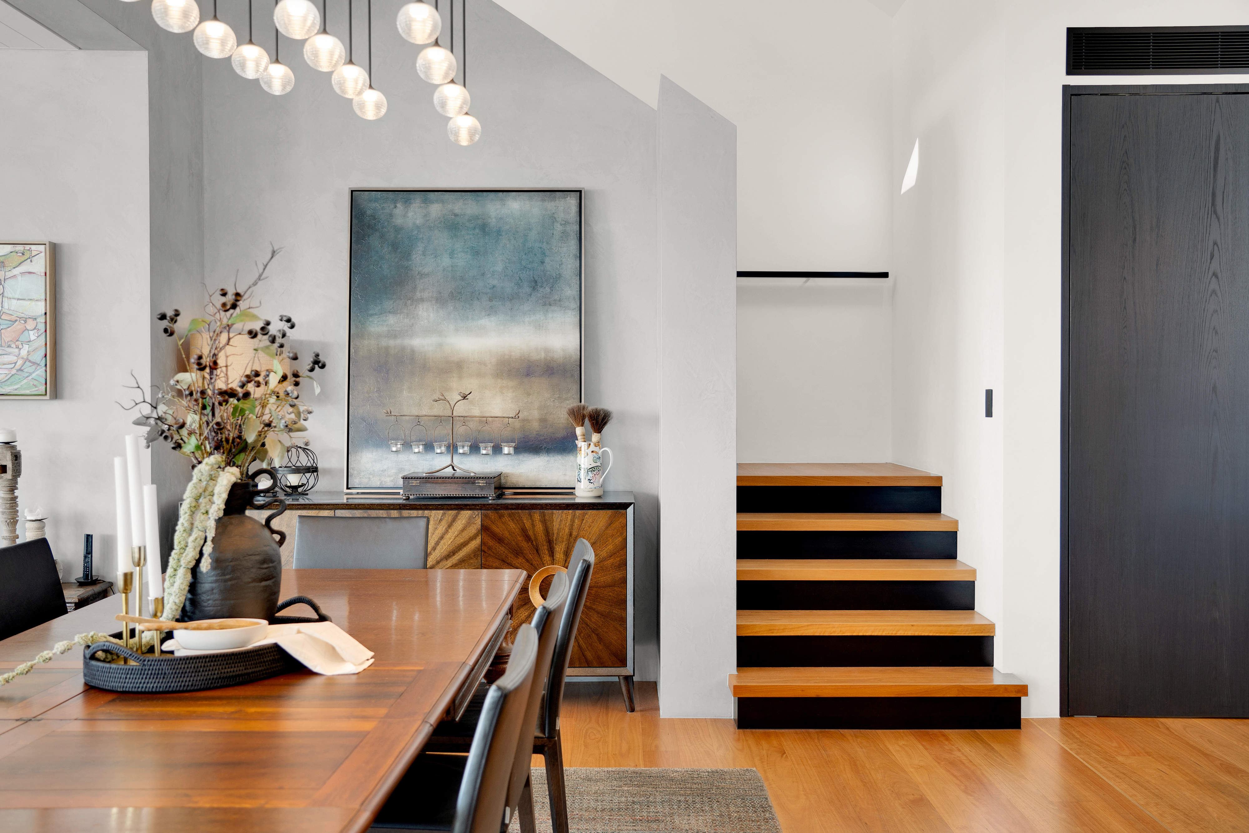 Dining area with chandelier and concrete walls — professional real estate photography